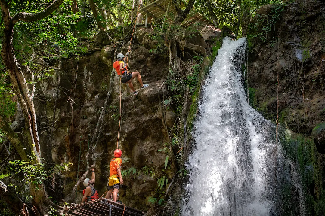Swimmers in the crystal pool beneath the waterfall, canyoning Costa Rica