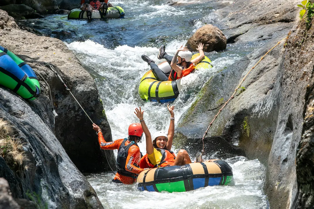 Tubing convoy through narrow crystal-clear jungle river
