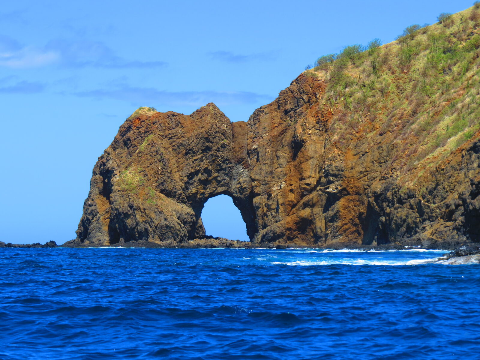 Natural rock arch rising above the Pacific Ocean at the Bat Islands in Guanacaste, Costa Rica.