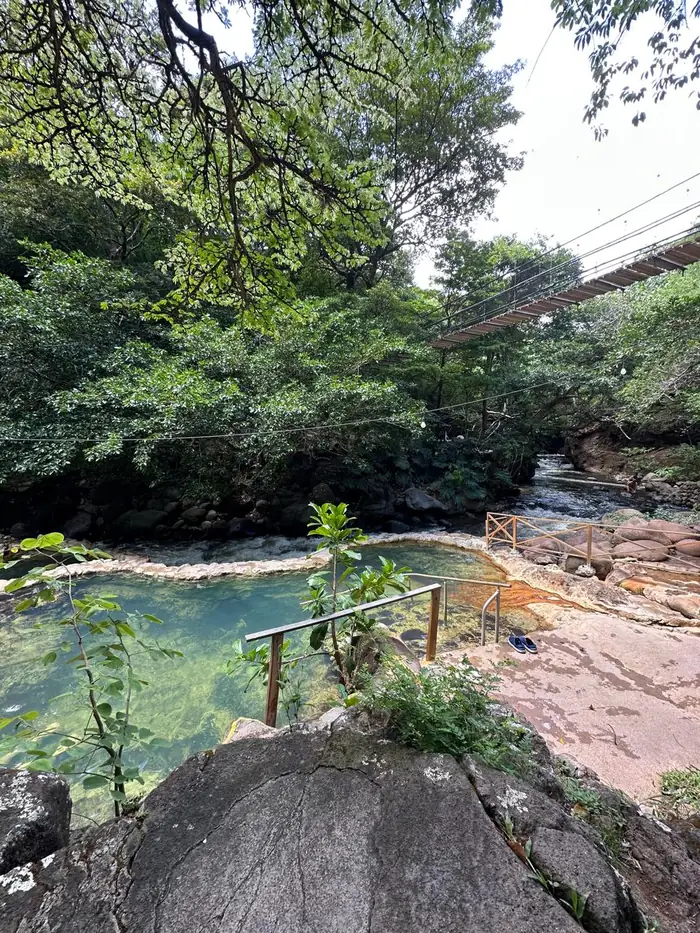 Natural Rio Negro hot spring pool beside the river, Guanacaste