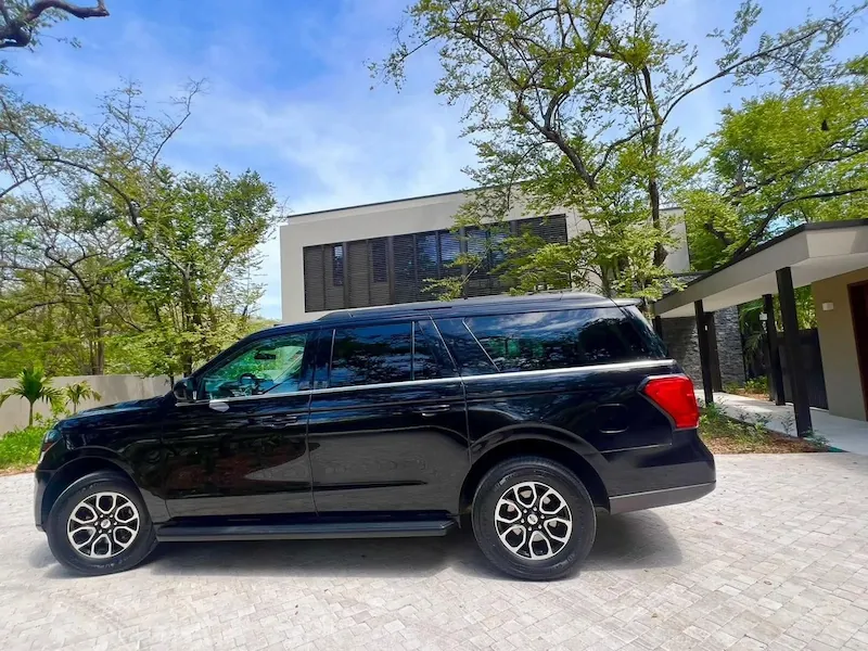 Black SUV parked in a driveway outside a modern house in Costa Rica